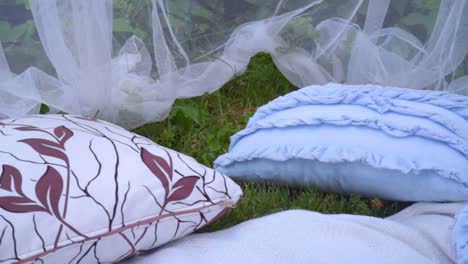 almohadas azules y tela transparente blanca en el parque. hermosa decoración de boda