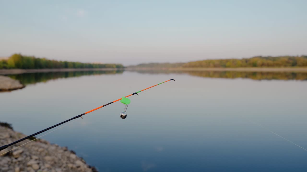 Ujung joran pancing yang dilengkapi lonceng. Peralatan memancing dalam close-up