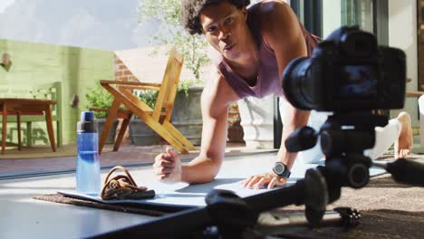 Fit-african-american-man-exercising-at-home,-doing-press-ups-and-filming-fitness-vlog