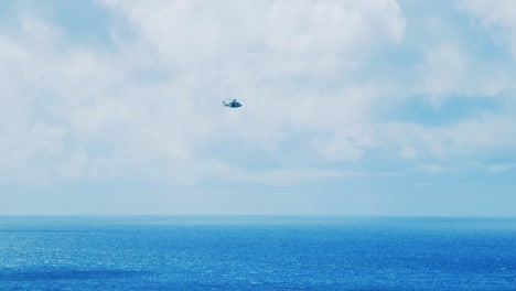 curacao coastguard helicopter flying across the ocean on a clear and sunny day in curacao