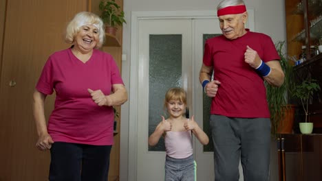 Enkelin-Und-Reife-Großeltern-In-Sportbekleidung-Machen-Zu-Hause-Sportliche-Jogging-Trainingsübungen