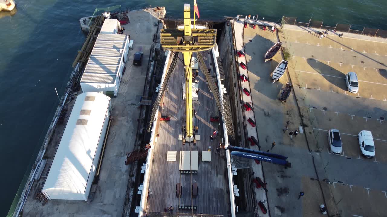 A drone shot flying over an old Portuguese vessel docked in Cacilhas, Portugal.