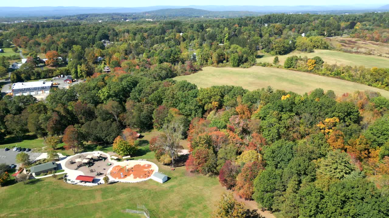 Groff Park with local play structure and terrace with autumn forest and green meadows from above, Amherst, Massachusetts, USA