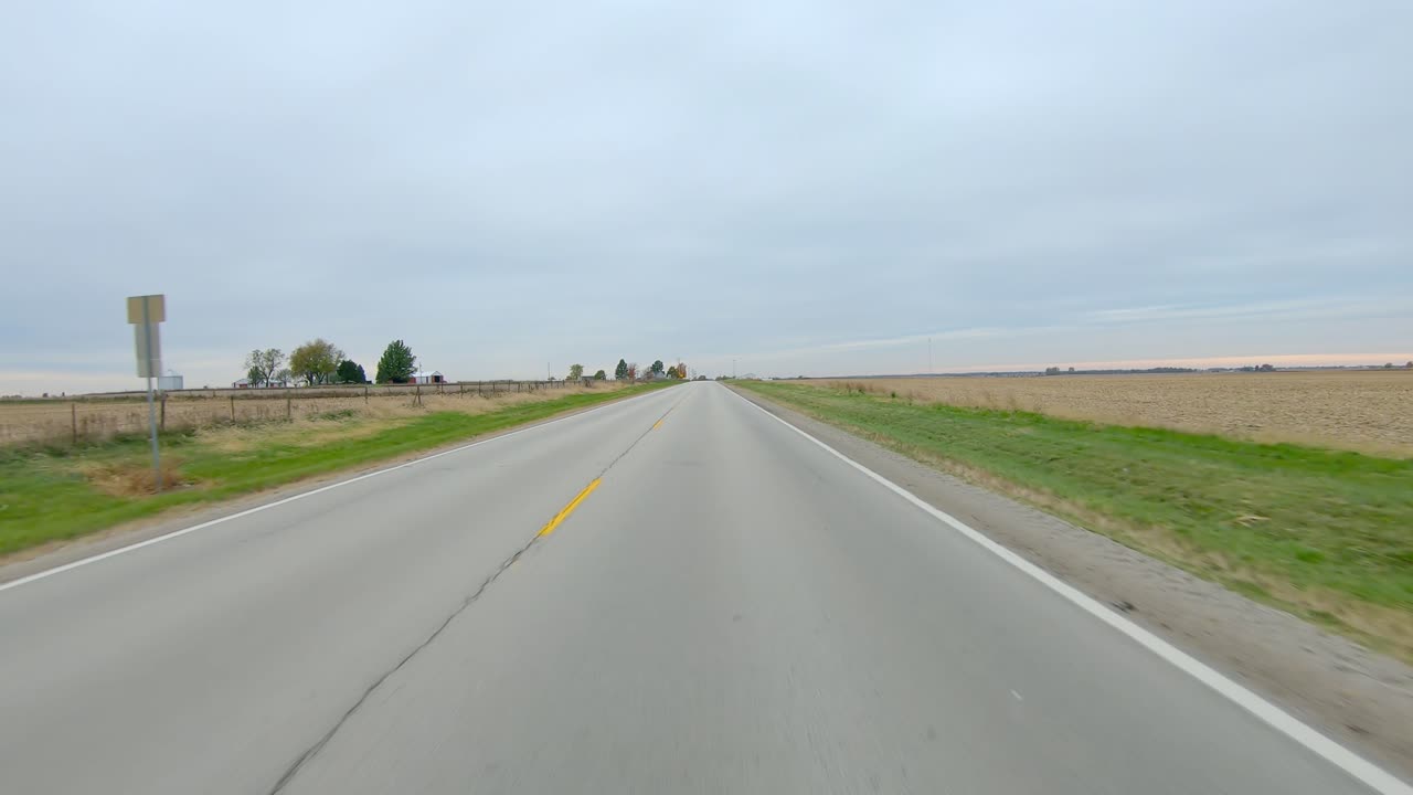 시골 동부 로와(lowa)의 흐린 겨울날 비어 있고 수확된 들판을 지나 좁은 시골길을 운전하는 포브
