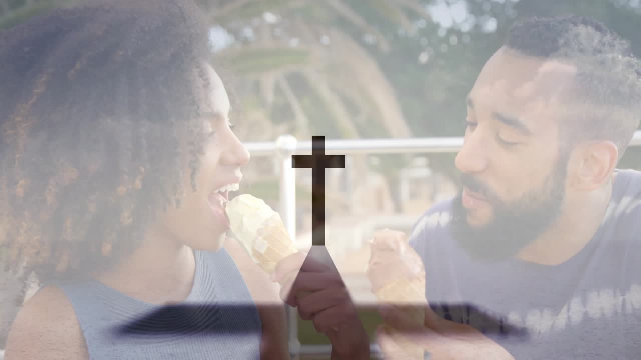 Couple tapping ice cream cones and sharing playful food bites on bench beside palm fronds