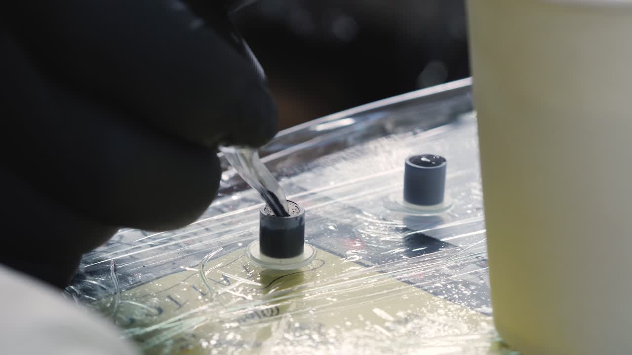 primer plano en cámara lenta del artista del tatuaje sumergiendo la aguja de la ametralladora del tatuaje con los guantes de tinta negra tienda de diseño de arte sydney nsw australia 4k
