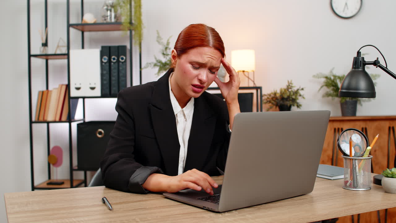 Young businesswoman feels sharp headache while working on laptop massages temples seeking relief now