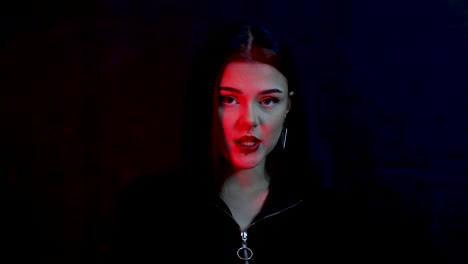 close up portrait of a beautiful caucasian model singing in red light in front of black background