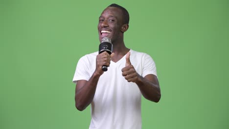 joven africano feliz sonriendo mientras habla en el micrófono