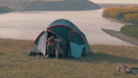 pudgy girl with hard hangover crawls from blue tent