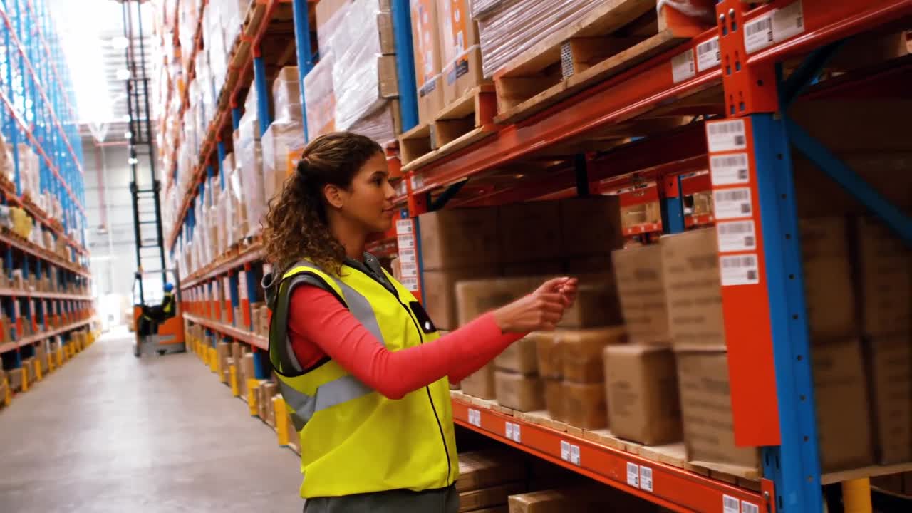 trabajadora retirando una caja de cartón del estante