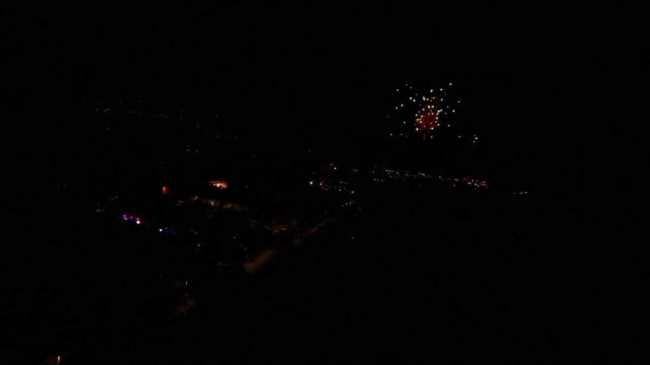 Slow motion, vibrant fireworks light up the night sky with color