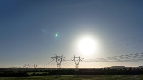 drone pushing towards powerlines catches sun flare