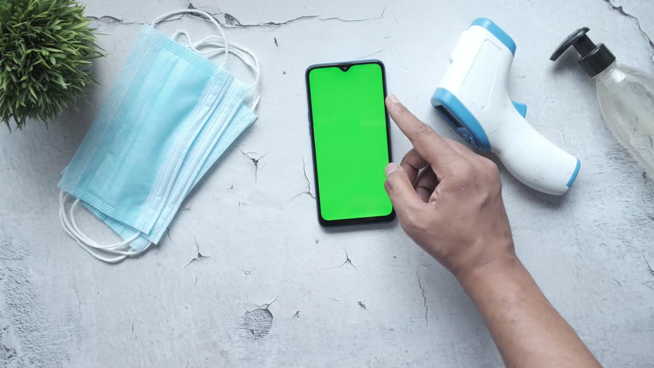 녹색 스크린, 마스크, 온도계, 위생제와 함께 스마트폰