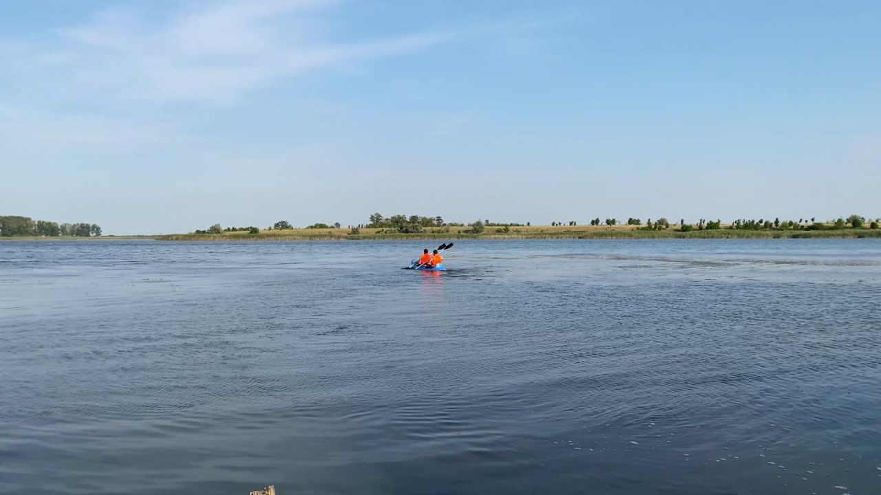 en el medio del río, uno puede ser testigo de dos individuos maniobrando el kayak