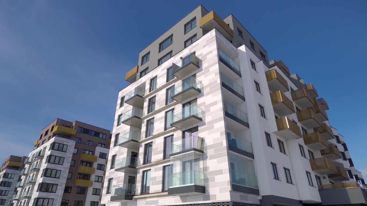 Modern blocks of flats with balconies on a sunny day with blue sky, truck left