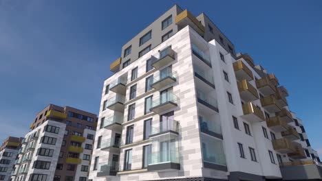 Modern-blocks-of-flats-with-balconies-on-a-sunny-day-with-blue-sky,-truck-left