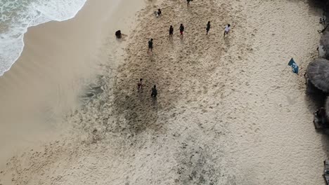 vista aérea, que muestra a los turistas jugando fútbol de playa en la playa de watu lawang, gunung kidul, yogyakarta, indonesia