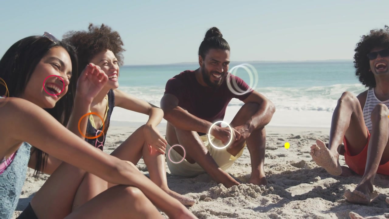 Quattro amici seduti sulla sabbia, chiacchierano mentre forme luminose appaiono vicino ai volti o alle mani per il marketing.