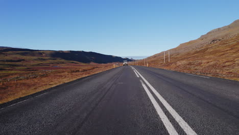 Vista-De-ángulo-De-Cámara-Baja-Del-Defensor-De-Land-Rover-Blanco-Conduciendo-Por-Una-Carretera-Rural-En-El-Sur-De-Islandia