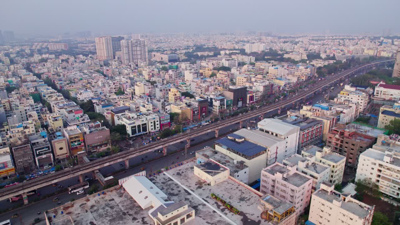 cityscape, metro train with track and moving vehicles at kukatpally, hyderabad, telangana, india. day time, push back, drone shot, 4k.