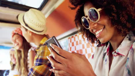 Woman-using-mobile-phone-while-friends-sitting-in-background-4k