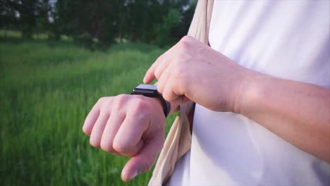 hombre ajustando un reloj inteligente en un campo