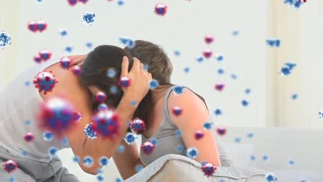 video compuesto digital de células de covid-19 moviéndose contra una pareja abrazándose en el fondo