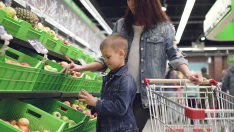 mother and son shopping for fruits at grocery store