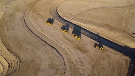 imágenes aéreas de drones de máquinas excavadoras en el desierto al atardecer