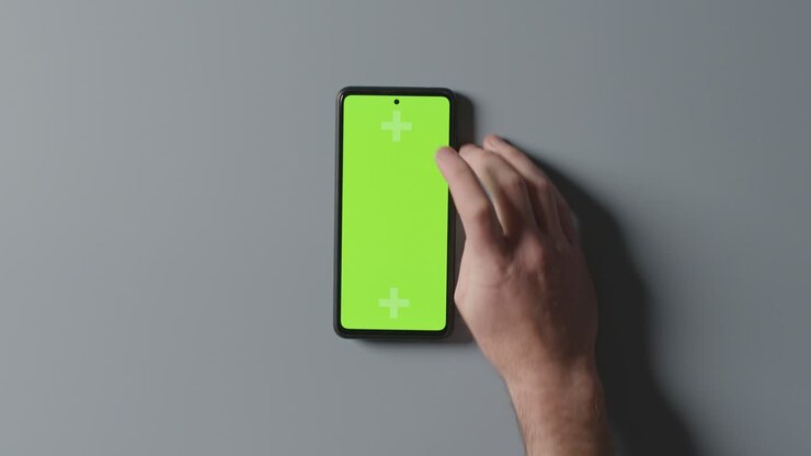 Ripresa aerea in studio di un uomo che usa un telefono cellulare con schermo verde 2