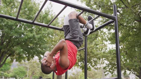Side view man with prosthetic leg doing abs suspended in the air