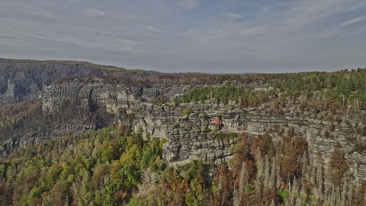 hrensko czechia aerial v1 cinematic drone flyover inverso en la ladera de la colina capturando el paisaje de las montañas rocosas con vistas al bosque quemado y el punto de referencia pravcicka archway - filmado con mavic 3 cine - noviembre 2022