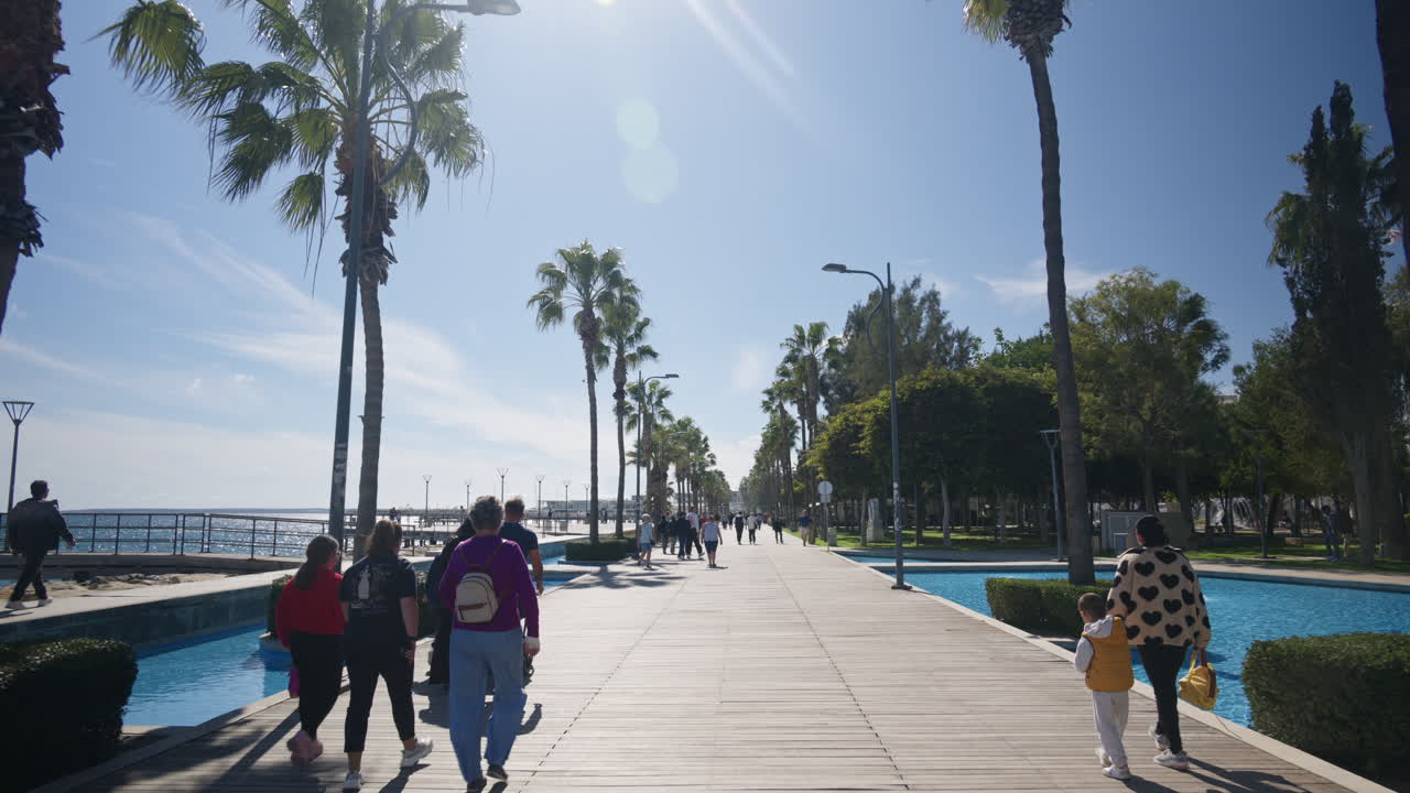 Limassol, Kypros - 26. helmikuuta 2026: Leveä kävelykatu, jota reunustavat korkeat palmupuut ja vesiaiheet.