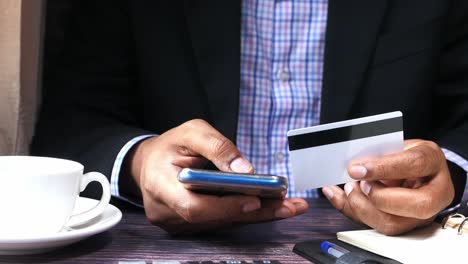 man using mobile phone and credit card for online payment