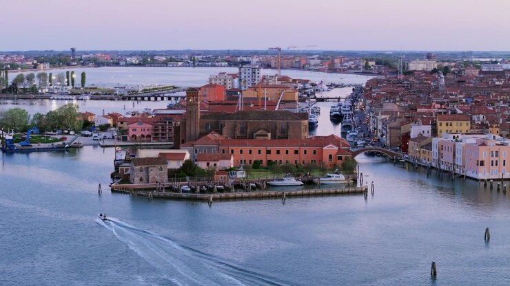 Ripresa aerea sopra l'isola alla foce del canale e il ponte a Chioggia, Italia