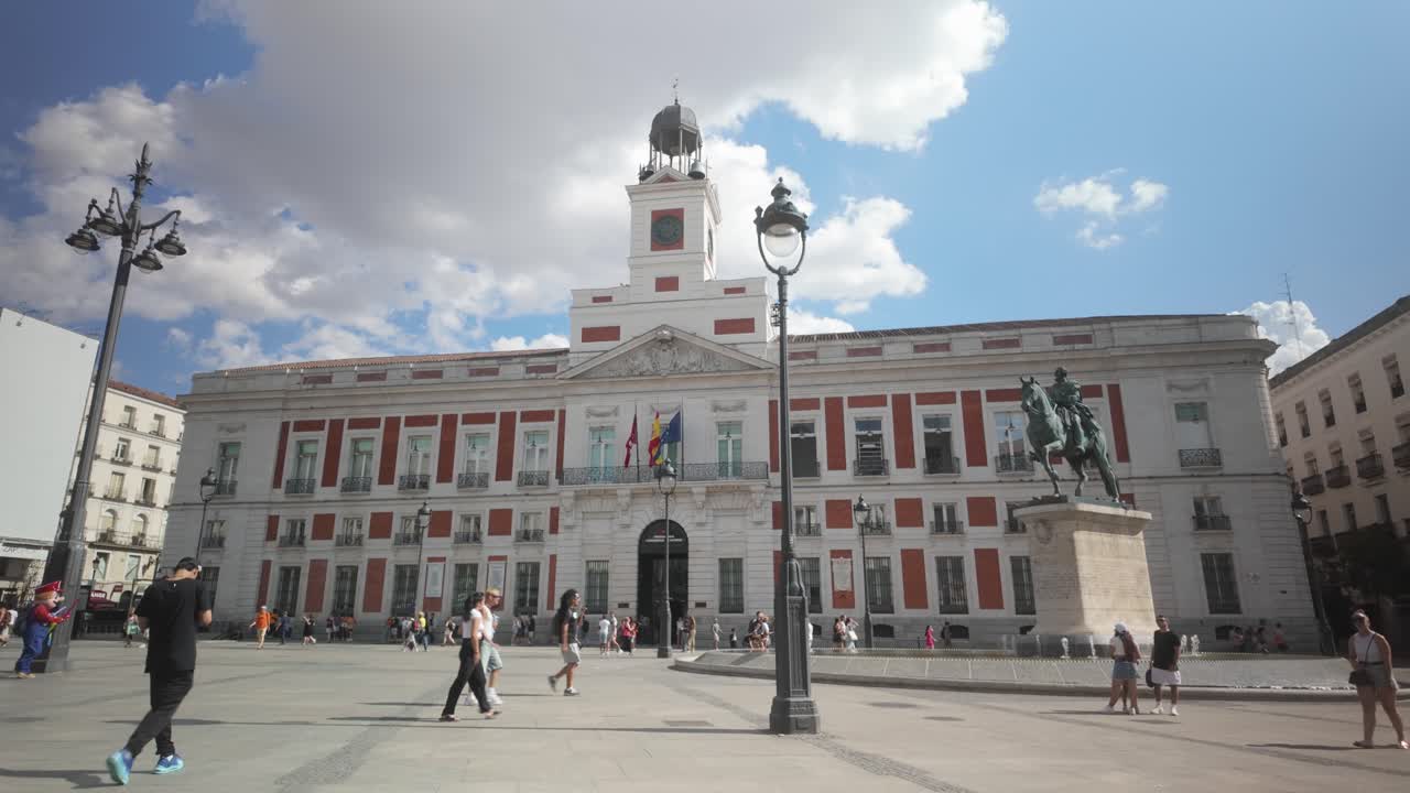 Close up shot of Casa de Correos facade Regional Government of Madrid (Old Post Office Building) and Carlos III Statue on a Sunny summer day blue sky and white cloud Puerta del Sol in Madrid, Spain