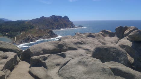 Nahaufnahme-Von-Erodiertem-Granitfelsen,-Bergige-Insel-Mit-Klippen-Und-Stränden-Mit-Hitzenebel,-Sonniger-Tag,-Panoramische-Aufnahme-Nach-Links-Abbiegen,-Cies-inseln,-Pontevedra,-Galizien,-Spanien