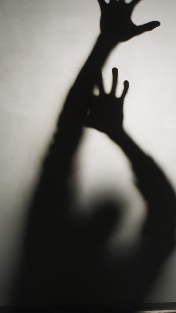 Vertical video of silhouette of man moving on white background