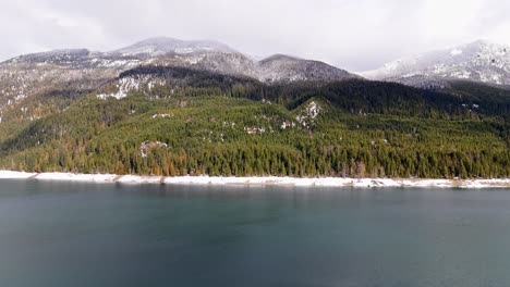 scenic forward shot of lake kachess with snow and evergreen forest in washington state