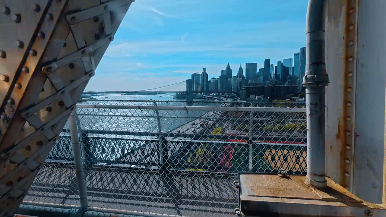 Vista do horizonte de Lower Manhattan a partir de uma ponte com a Ponte do Brooklyn. Ampla paisagem de arranha-céus do distrito financeiro e ponte pênsil icônica sobre o East River sob céu azul