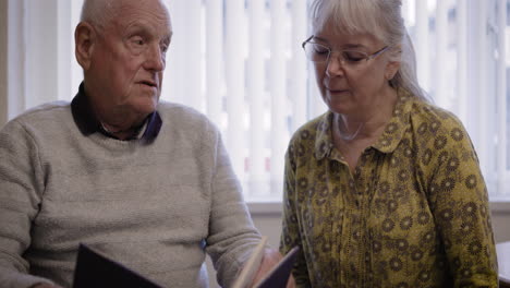 elderly couple looking at a photo album