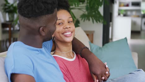 Video-Eines-Glücklichen-Afroamerikanischen-Paares,-Das-Auf-Dem-Sofa-Sitzt-Und-Sich-Umarmt