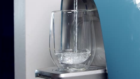 close up slow motion of a water cup filling in a water filtering machine