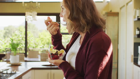 Perfil-De-Una-Mujer-Embarazada-Caucásica-Parada-En-La-Cocina-Y-Comiendo-Helado