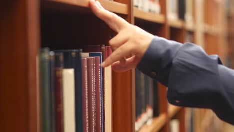un hombre buscando y hojeando libros en una biblioteca