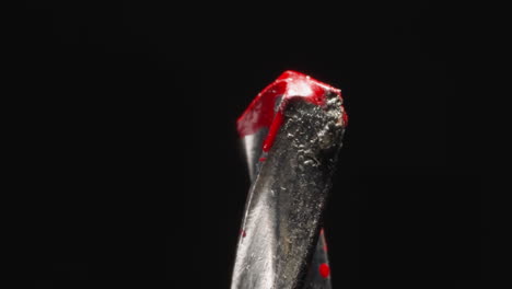 twisted tip of concrete drill in red paint at studio light