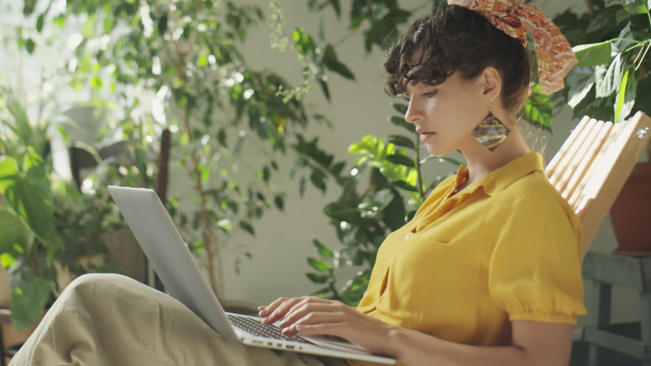 Woman Working on Laptop in Indoor Garden