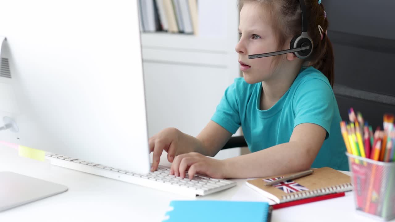 Young girl with headset engaged in online learning or communication on computer