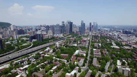 Aerial-view-over-the-Little-Burgundy,-toward-the-Montreal-skyline,-summer-in-Canada